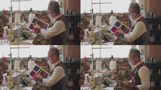 一名亚裔中国高级男子在工作室展示变种纺织面料样本目录视频，用数字平板电脑与客户通话