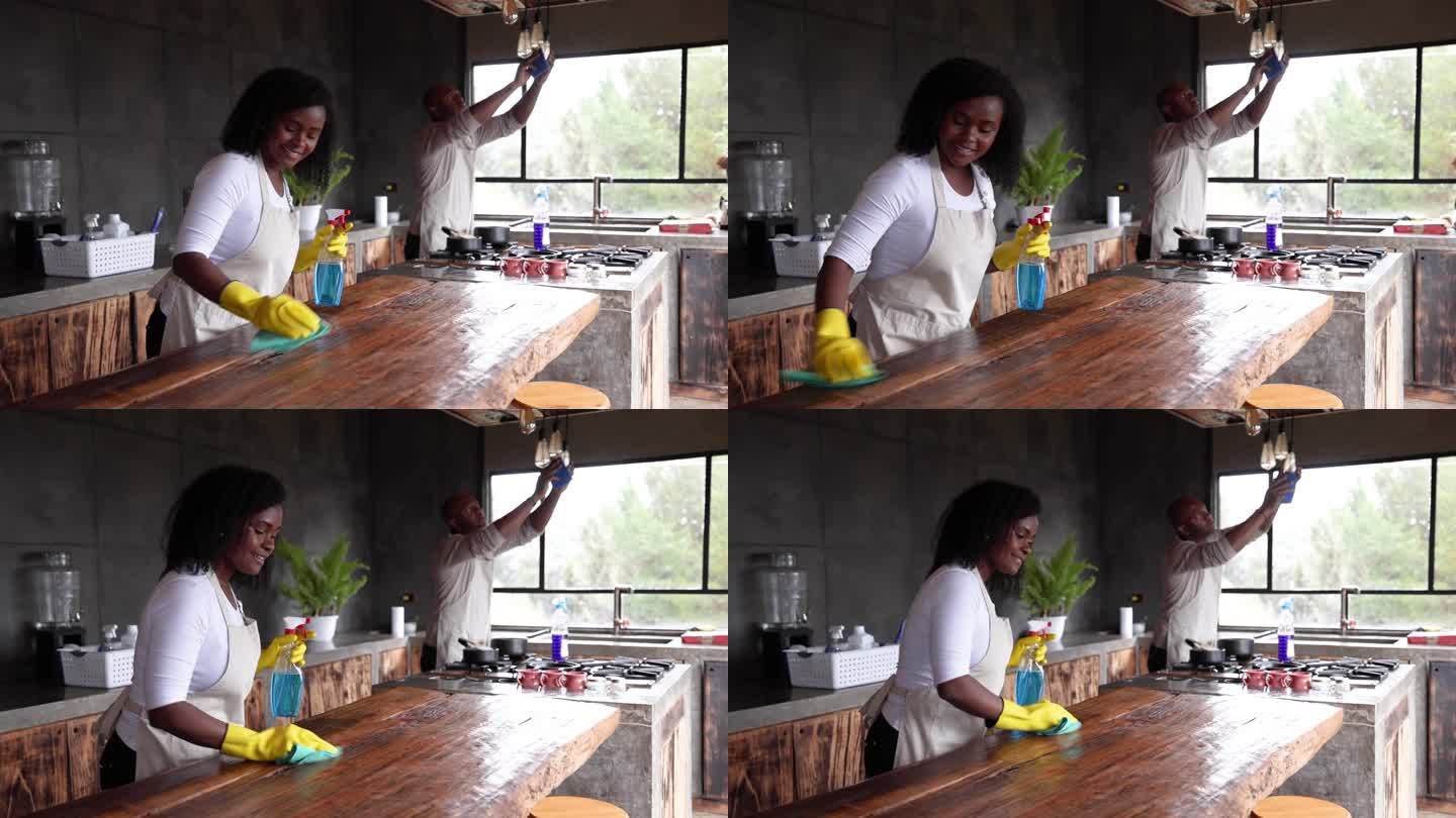 快乐的美国黑人夫妇在家做家务，一起打扫厨房