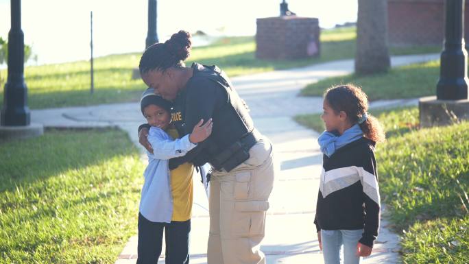 社区里的女警察，带着两个孩子散步