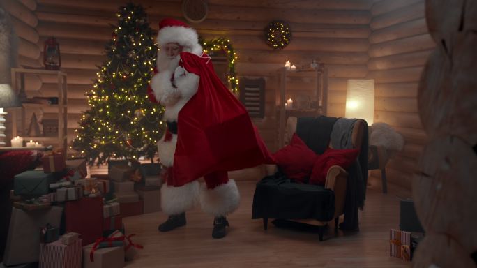 圣诞老人带着红色的袋子走进办公室，坐在扶手椅上