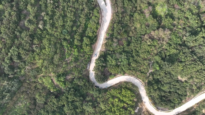 汽车行驶在蜿蜒崎岖的山路上航拍