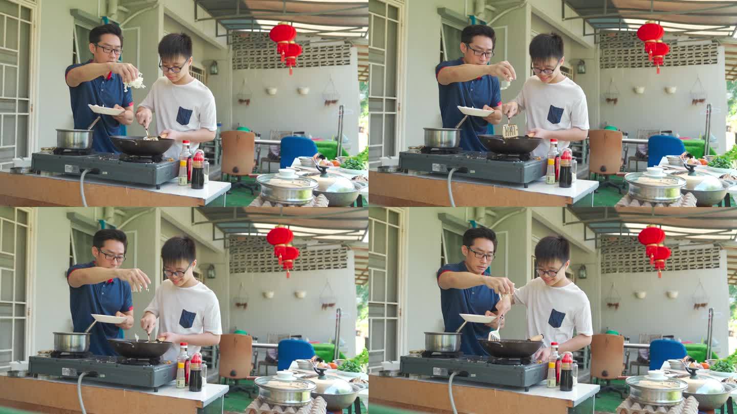 周末，亚裔中国父亲和儿子在潮湿的厨房后院一起做饭准备晚餐