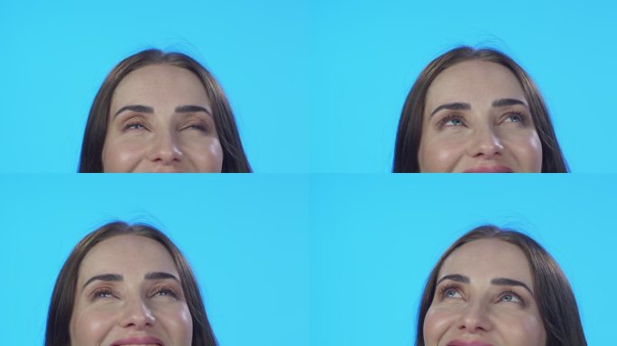 4k视频片段，一位迷人的年轻女性在蓝色工作室背景下显得若有所思