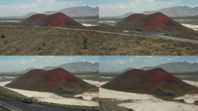 鸟瞰图，一男一女坐在山顶上，看着土耳其的红色火山口