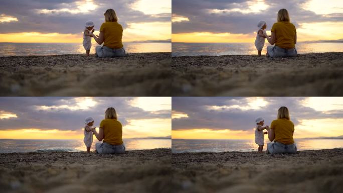海滩上的年轻母亲和活泼的女婴