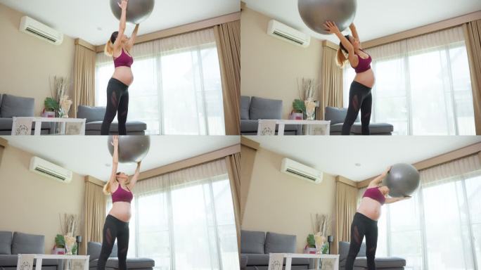 亚洲年轻孕妇在起居室做普拉提瑜伽锻炼。身穿运动服的漂亮怀孕妈妈在家里进行健康保健运动时，感到快乐和放