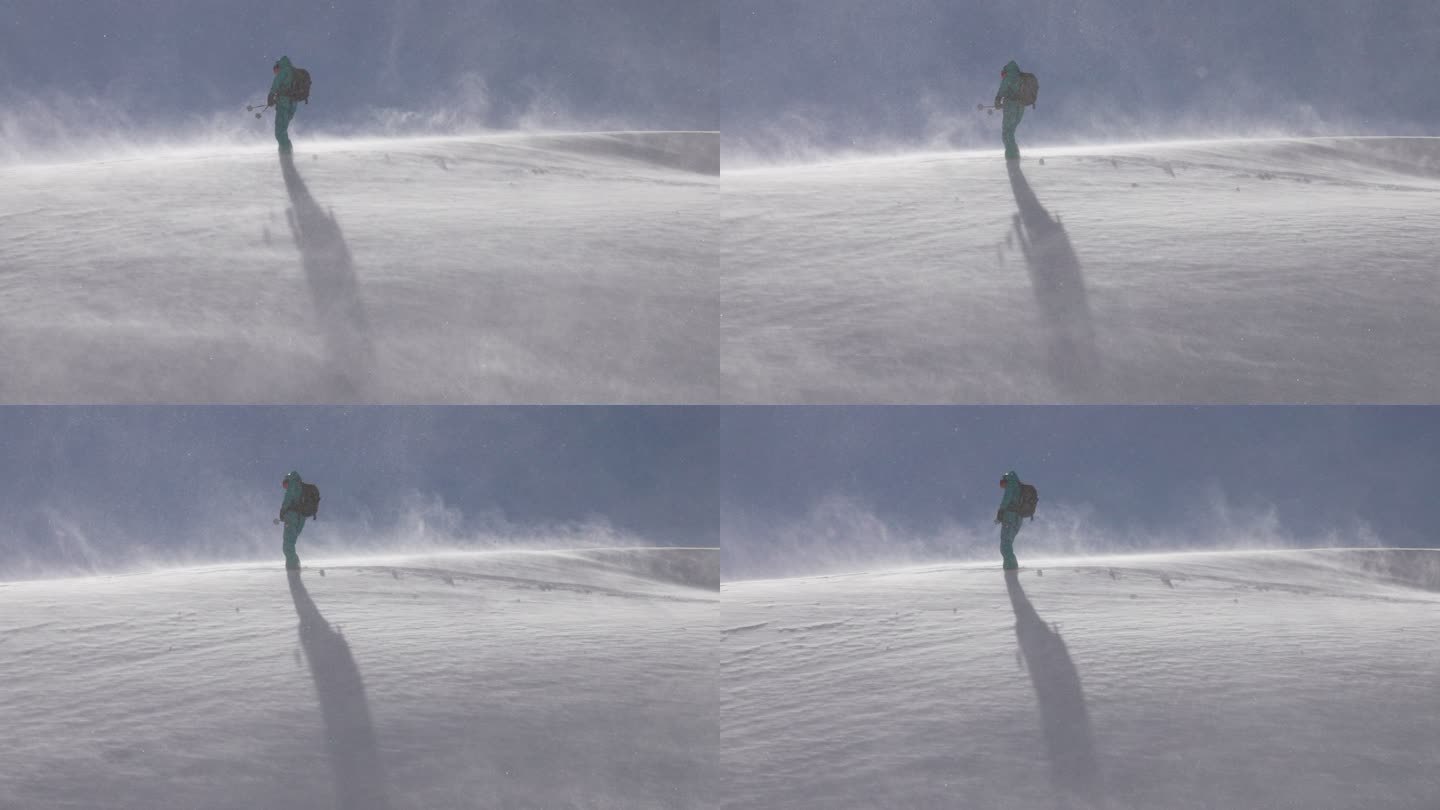 孤单的滑雪者站在雪山上，雪花飘飘