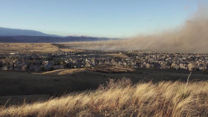 科罗拉多州博尔德郊外马歇尔大火中，烟雾弥漫的尘埃云席卷着火的草原