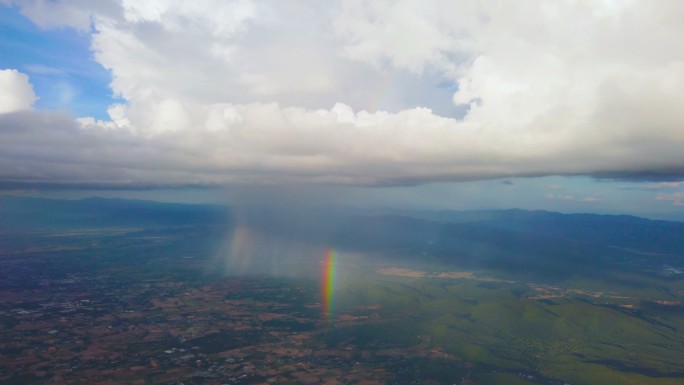在云天和彩虹的飞机上从窗口观看风景
