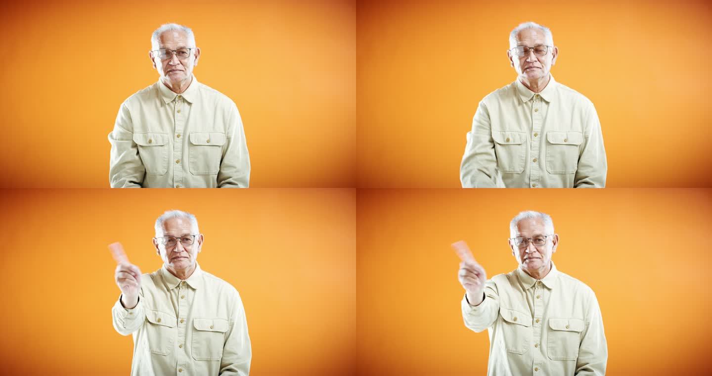 一名高级男子在橙色工作室背景下摇动手指的4k视频片段