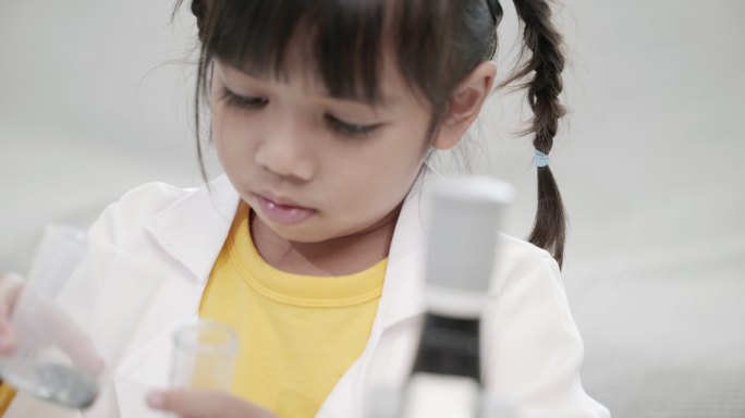 亚洲小女孩在学校进行科学实验的场景