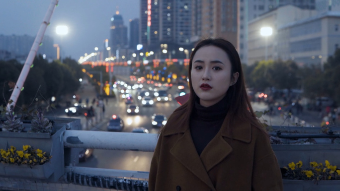 年轻女子在雨夜的街头和天桥