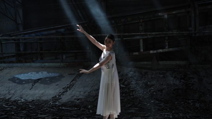 年轻女子美丽的芭蕾舞演员在黑暗中与光明共舞。放大