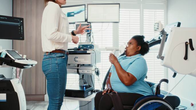 医生对残疾患者进行肺容量测试。利用肺功能数据分析技术获得最佳血氧水平。医院医疗专业轮椅女性检查