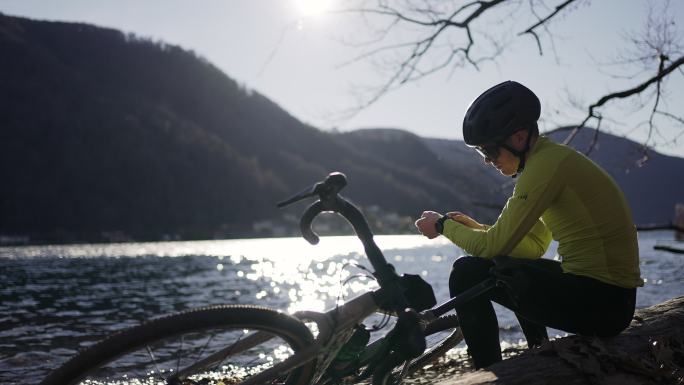 骑自行车的人在湖边休息，眺望风景