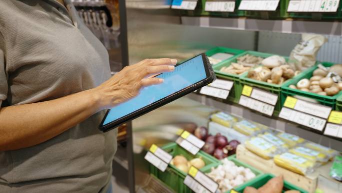 女性使用数字平板电脑控制超市库存