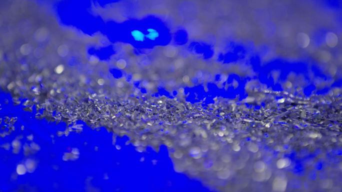 慢速特写镜头，在充满活力的蓝色表面上散落着许多小的铝金属屑
