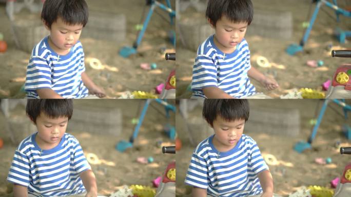 小男孩在操场上玩沙子。
