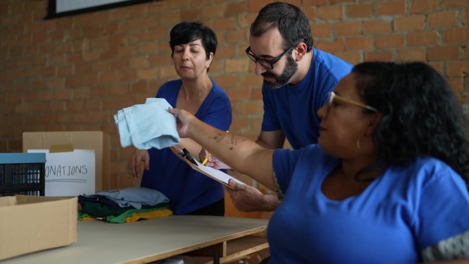 志愿者在慈善捐赠中心整理衣服——包括一名残疾人