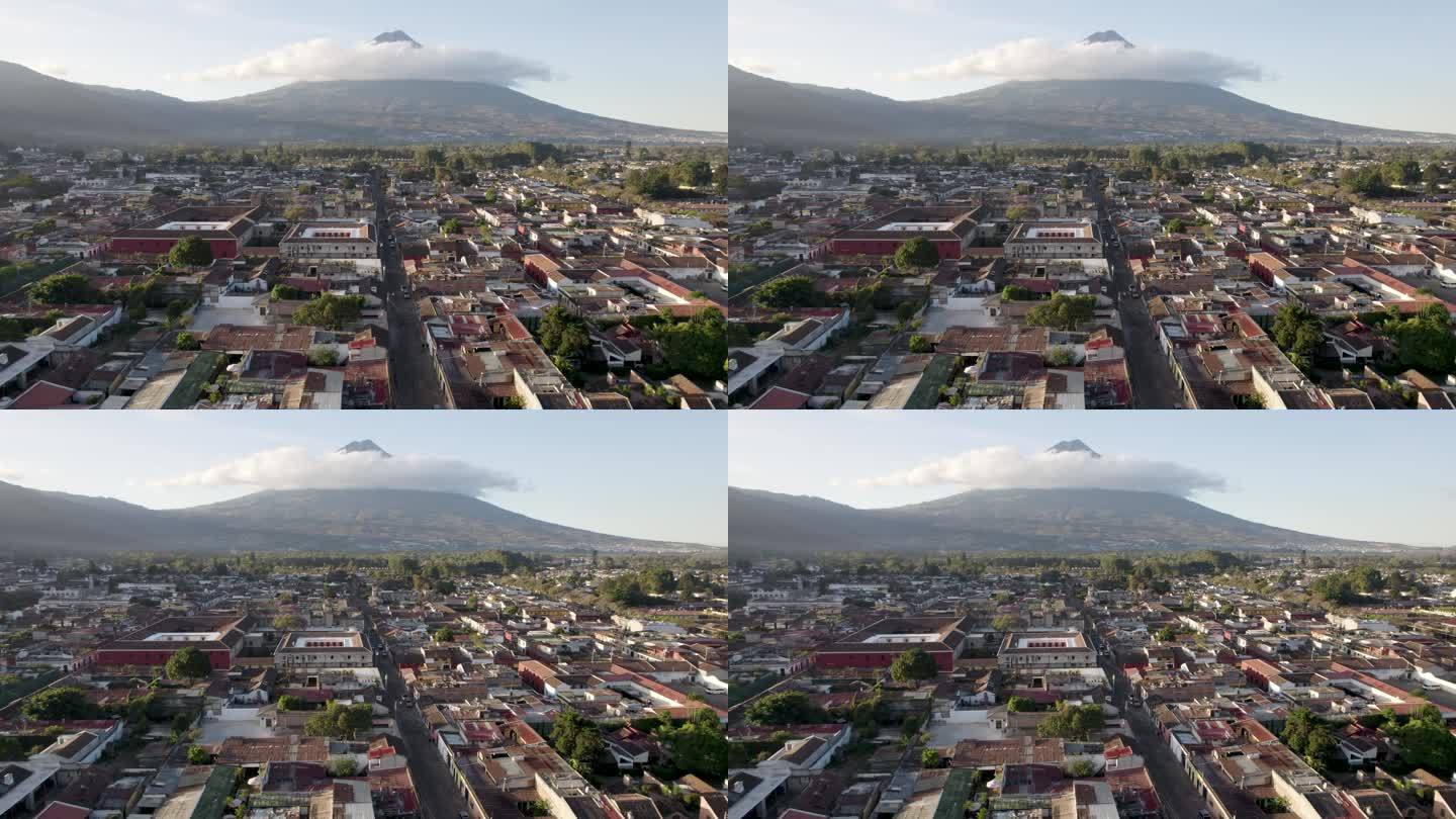 在阳光明媚的日子里，安提瓜危地马拉静止的阿瓜火山、鹅卵石街道和屋顶的景色