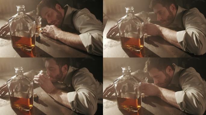 一个穿着衬衫的醉汉在黑暗的酒吧里的桌子上睡着了，他醒来后，从手中的杯子里喝了一口威士忌，然后又睡着了