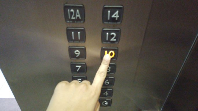 用手指按下10楼电梯的关闭按钮