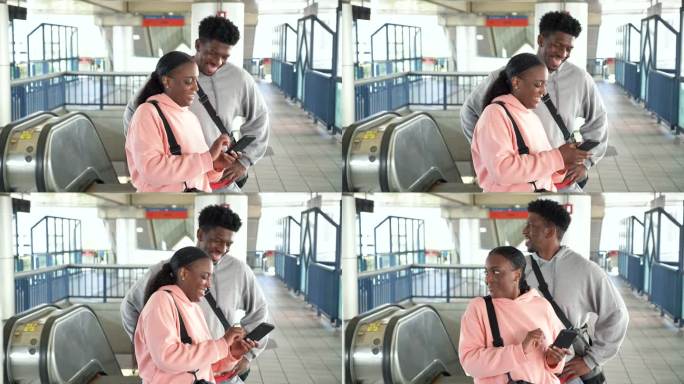 火车站台上的一对黑人夫妇看着手机