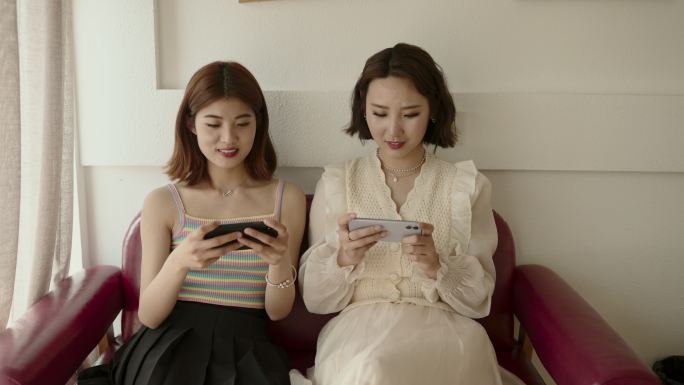 亚洲年轻女性玩手机游戏