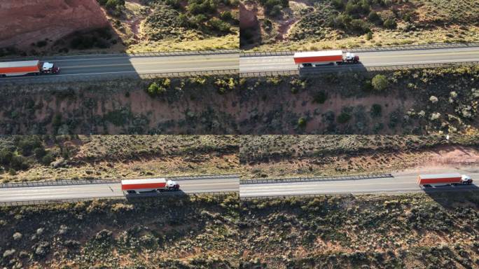 无人机视图半卡车在犹他州西南部摩押附近的红岩砂岩地区沙漠中沿四车道公路加速行驶