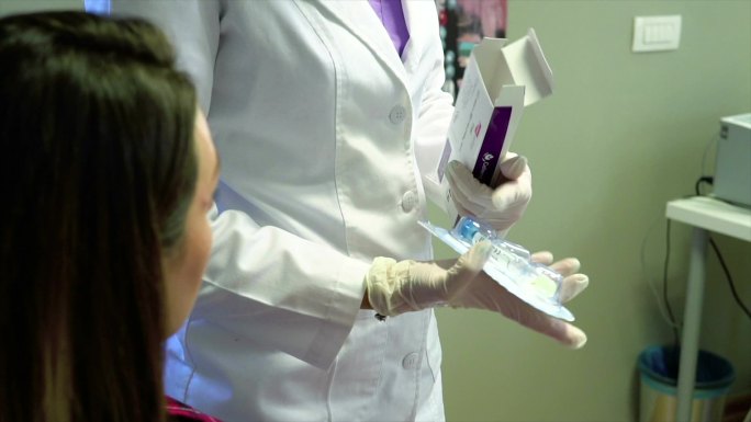 年轻女性美容师在诊所库存视频中从安瓿中回收液体