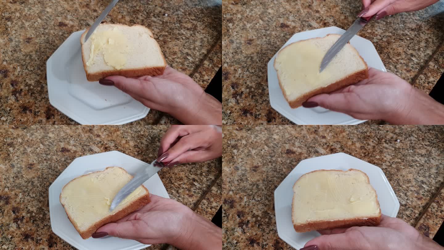 女人在面包上涂黄油