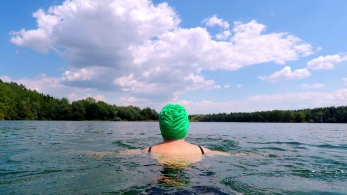 戴泳帽在湖中游泳的女子