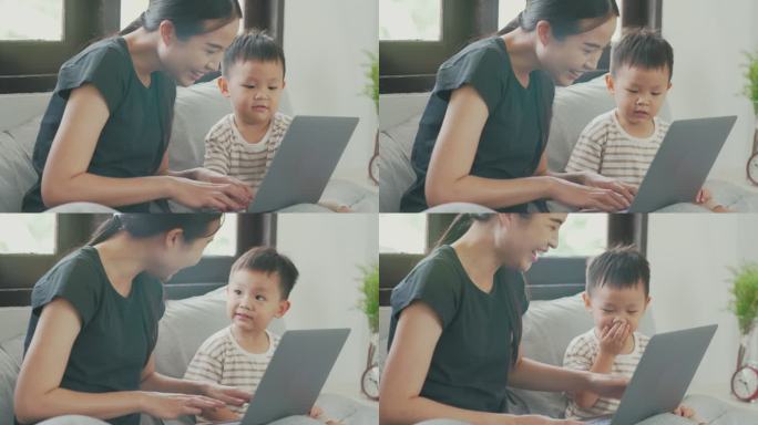 母亲和她的小男孩玩电脑的镜头。
