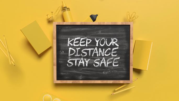 返回学校保持距离保持安全概念，在4K分辨率的黄色背景黑板后面放置黄色学校设备
