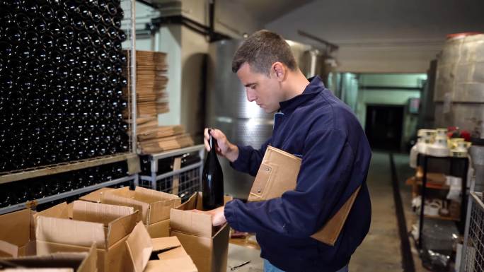 酿酒厂的工人检查酒窖中的葡萄酒质量