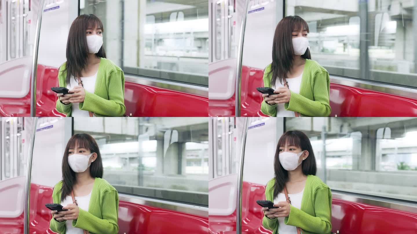 年轻的亚洲女性一边在火车上上班，一边阅读手机银行交易的电子邮件。