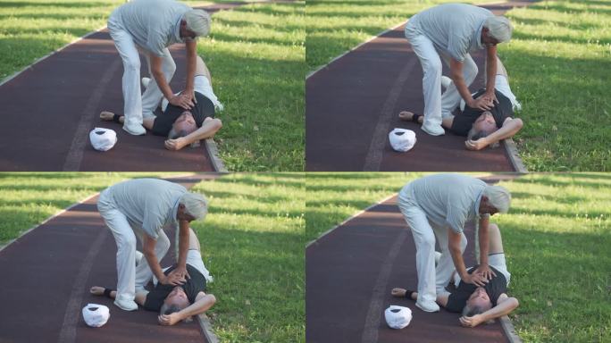 老人正在进行心肺复苏术，而他的朋友躺在地上，长跑后无法呼吸