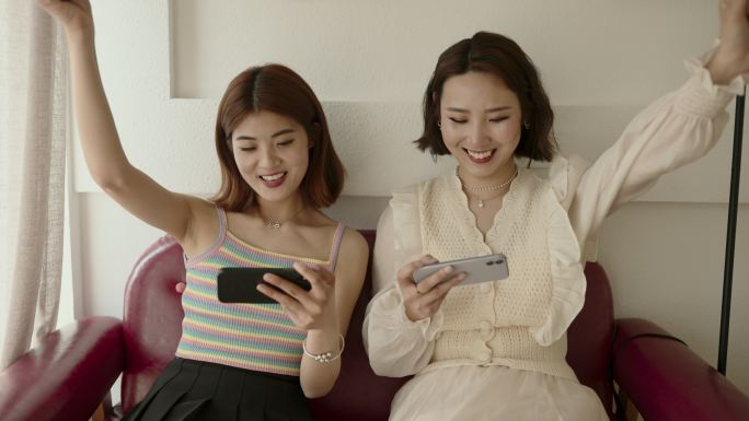 亚洲年轻女性玩手机游戏