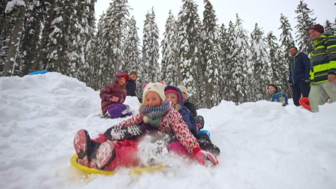 SLO MO TS孩子们滑下雪山，从雪橇上摔下来