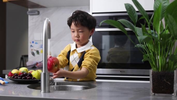 小男孩正在厨房里洗水果