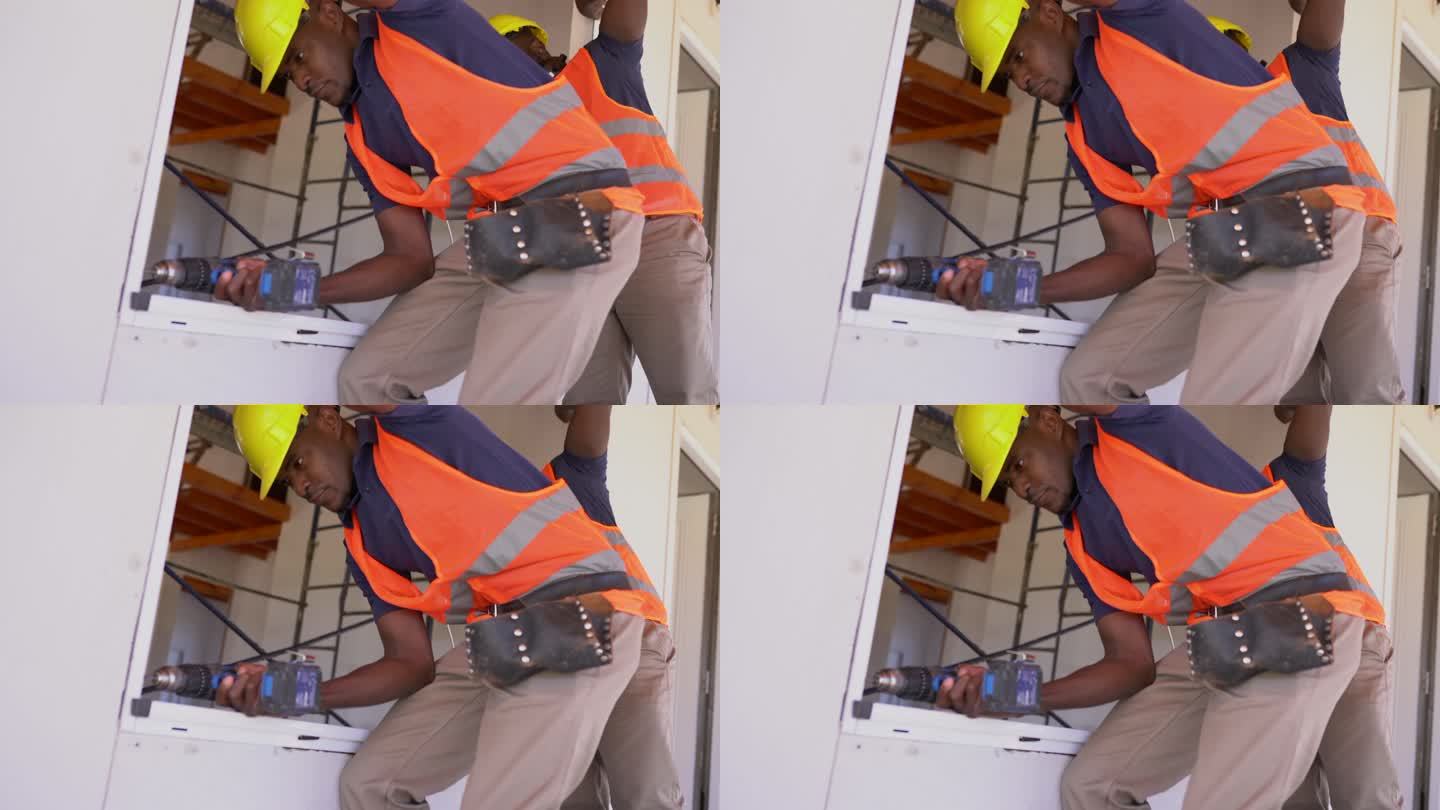 美国黑人建筑工人在木结构房屋施工中安装窗户
