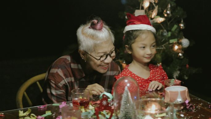 侄女和祖母在圣诞派对上拍照后吹纸屑-库存视频