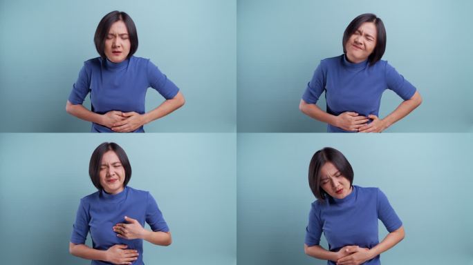 亚洲女性在蓝色背景下出现胃痛。4K视频