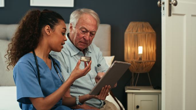 4k视频片段，一名护士拿着药物，在数字平板电脑上向年长的患者展示一些东西
