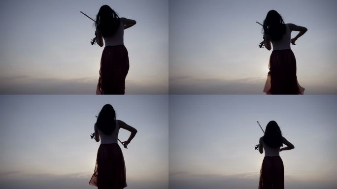 日落时分，山上的年轻女子在海上背景上拉小提琴。