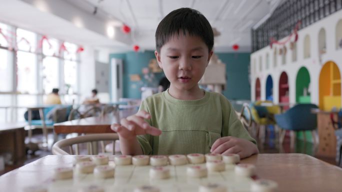 一个小男孩在下中国象棋