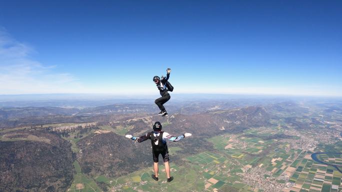 跳伞者在瑞士山地上空翱翔