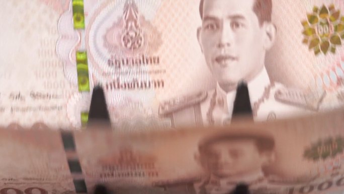 泰国钞票1000泰铢（1,00泰铢）在钞票柜台机器中计数的慢动作特写镜头，货币，计数，银行柜台，机器