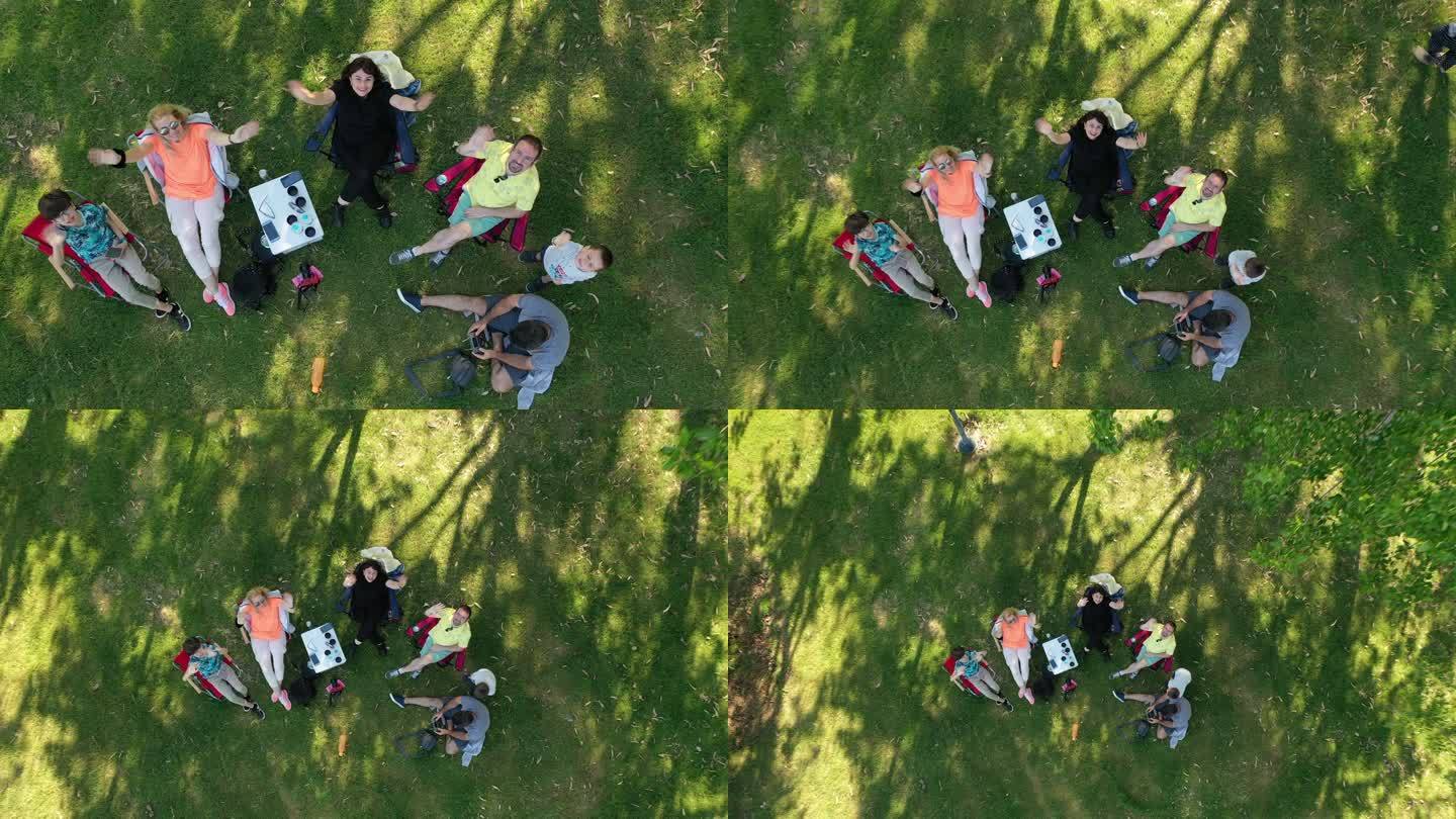 公园里快乐的朋友向相机挥手的高角度视图