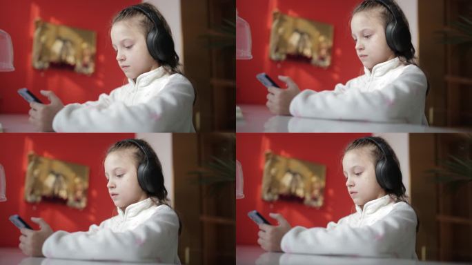 这个可爱的金发女孩玩一个带蓝牙耳机的智能手机